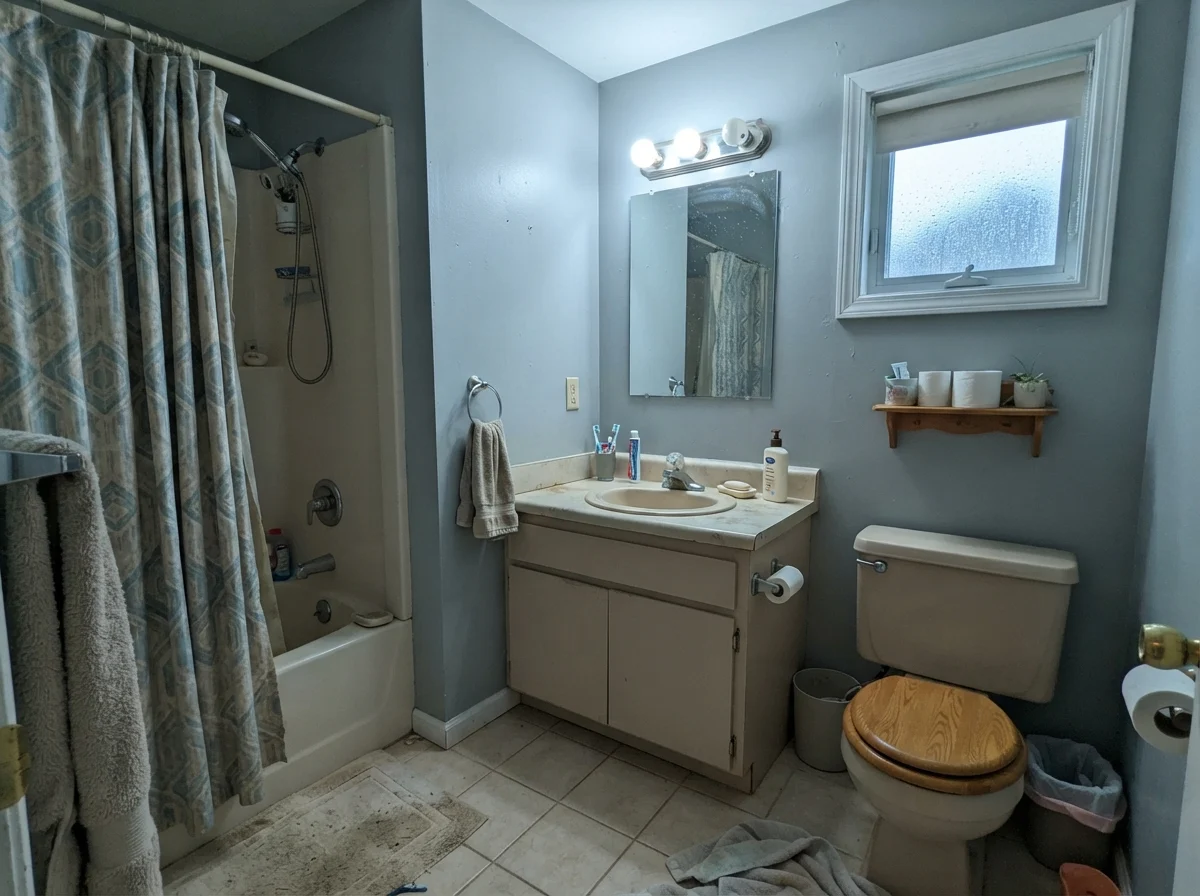 Dated bathroom under cool northern light showing Boothbay Gray picking up a cool undertone.