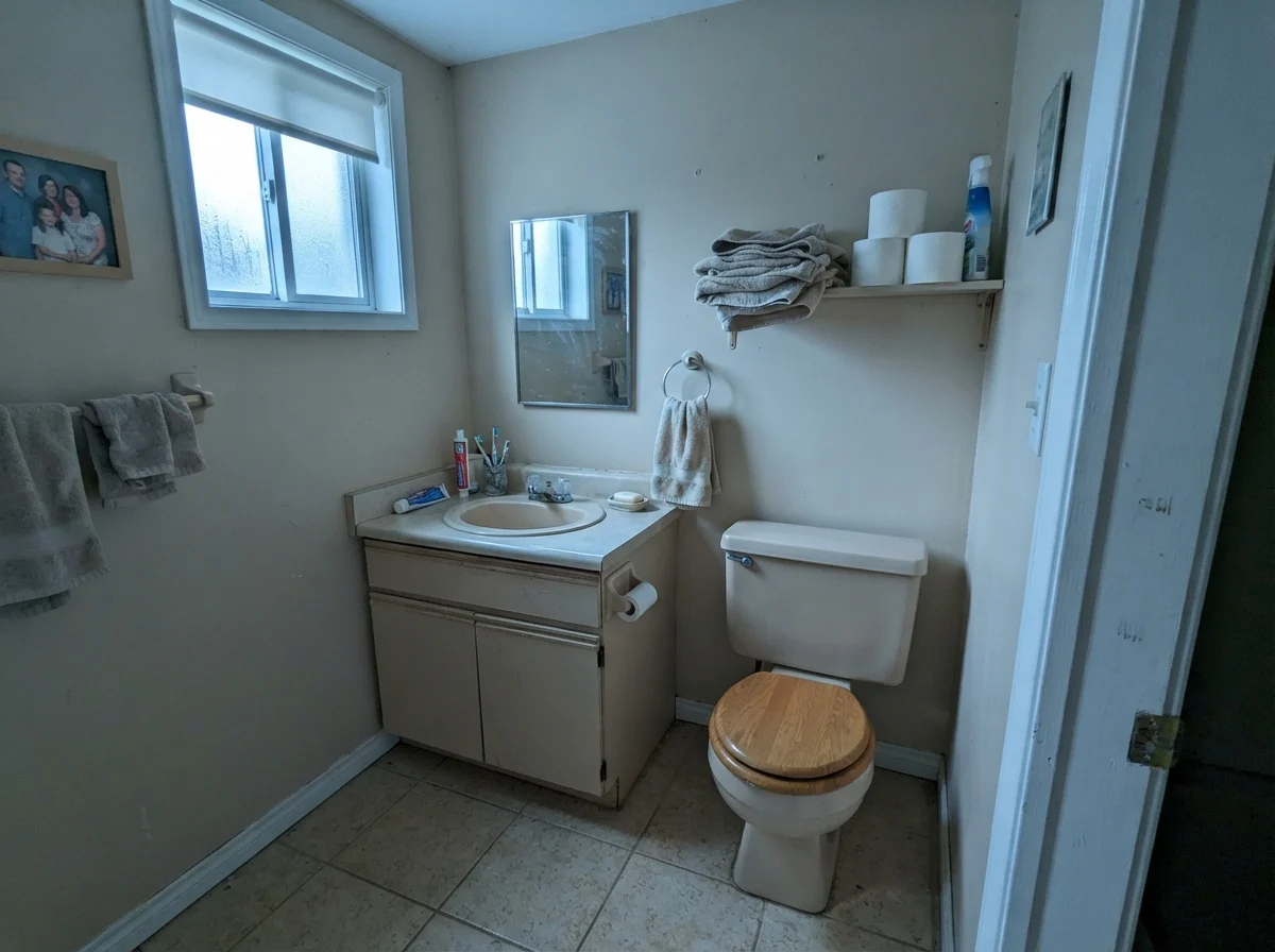Dated bathroom in north light with Manchester Tan painted walls showing a cooler cast