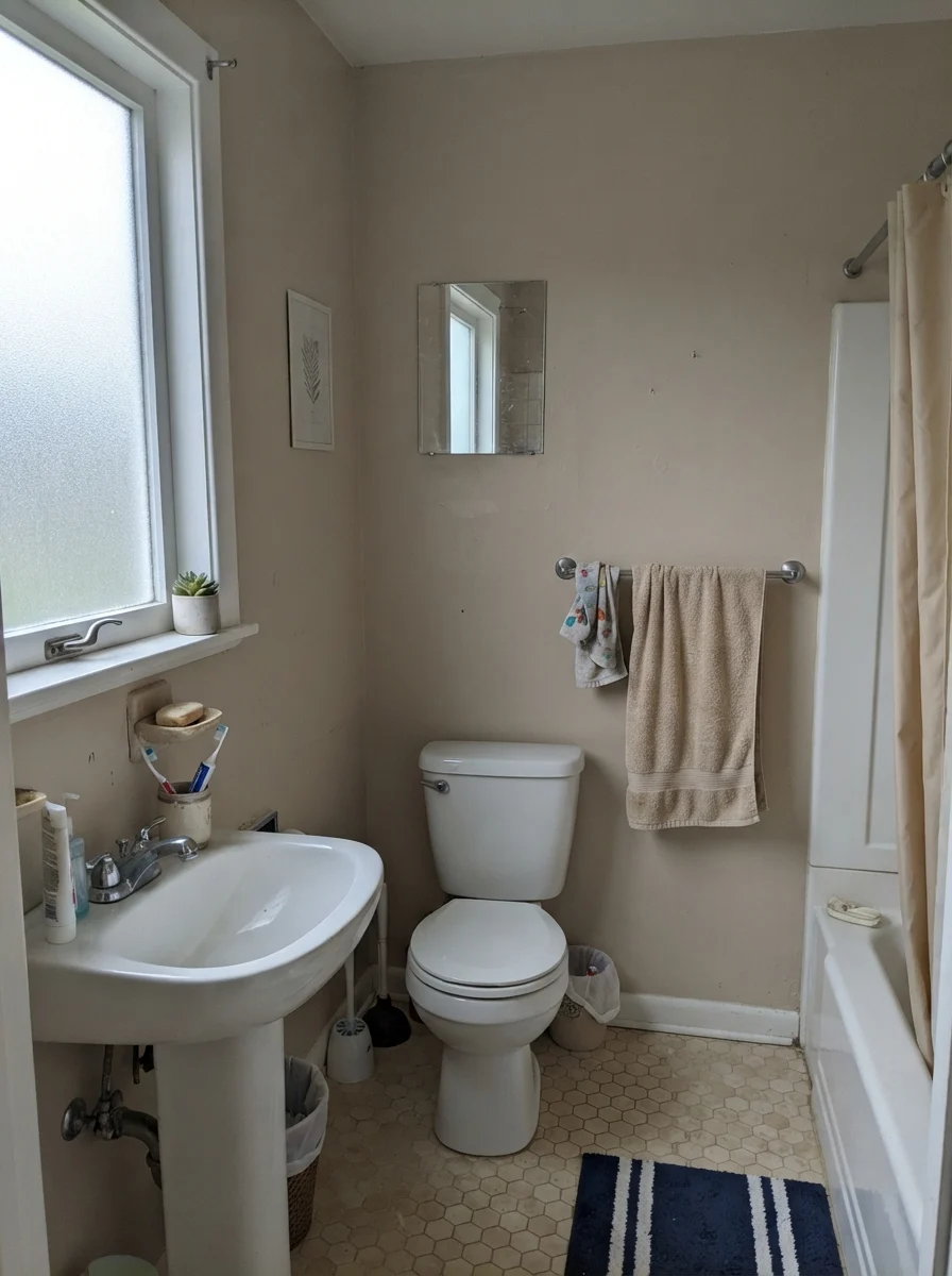 Small bathroom with Kilim Beige walls appearing muted under flat overcast daylight through a frosted window.