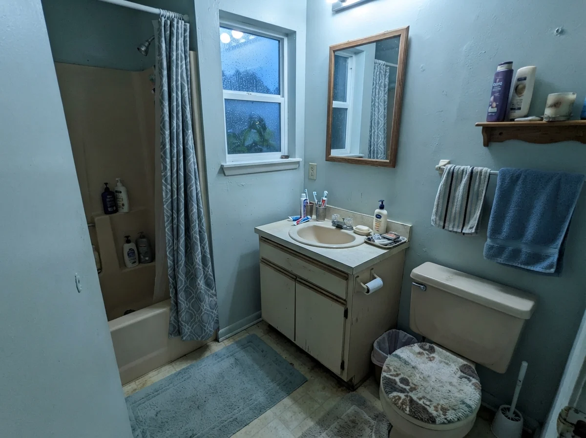 Modest dated bathroom with cool north light casting a blue-gray tone on Tradewind walls